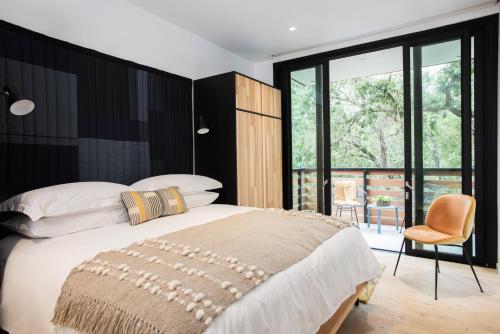 a bedroom with a large bed and a chair at Harmon Guest House in Healdsburg