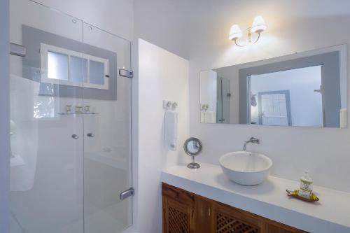 a bathroom with a sink and a glass shower at Pousada Casa de Paraty in Paraty