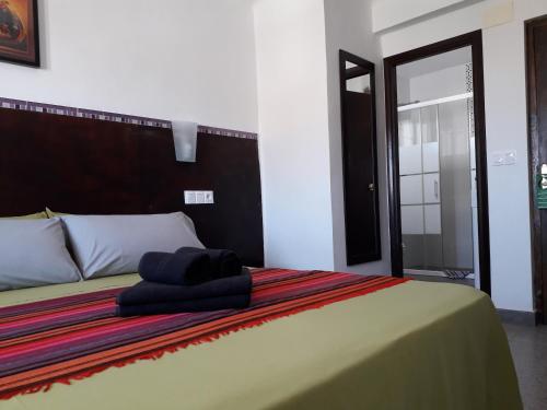 a bed with two towels sitting on top of it at Boutique Hostal "Casa Justa" in Mojácar