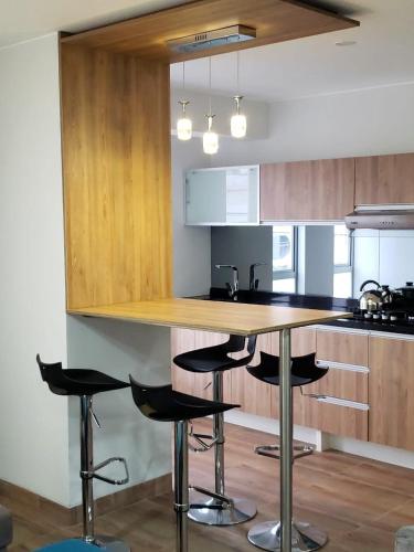 a kitchen with a counter and stools in it at Residencial Cafferata in Lima