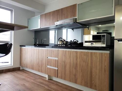 a kitchen with wooden cabinets and a microwave at Residencial Cafferata in Lima