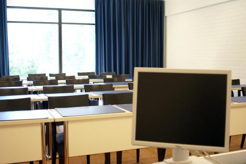 a classroom with desks and a computer monitor in it at Finlandia Hotel Imatran Kylpylä Spa in Imatra