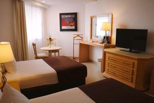 ein Hotelzimmer mit 2 Betten und einem Flachbild-TV in der Unterkunft Hotel Laffayette Ejecutivo in Guadalajara