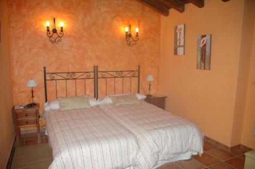 a bedroom with a bed and two night stands and lamps at Casa Rural El Pedroso in Villar del Pedroso