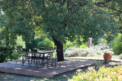 a table and chairs under a tree in a garden at Villa COLIBRI in Lorgues