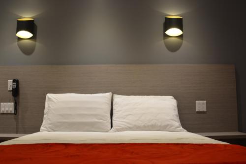 a bedroom with a bed with two lights above it at Motel Chez Nous in Laval