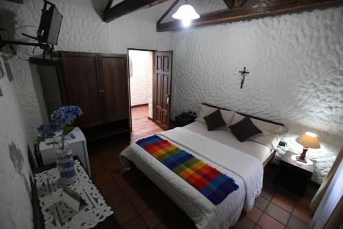 a bedroom with a bed and a cross on the wall at HOTEL Quito Antiguo in Quito