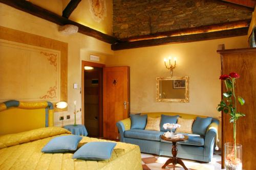 a bedroom with a bed and a couch at Hotel Leon D'Oro in Orta San Giulio