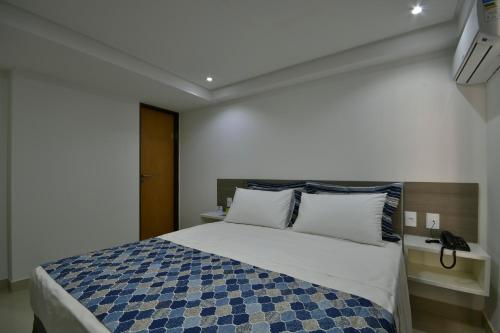 a bedroom with a bed with a blue and white blanket at Littoral Gold Flat in João Pessoa