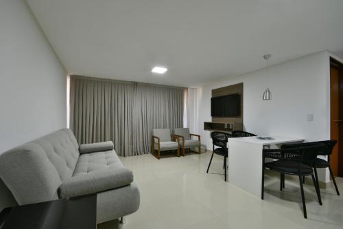 sala de estar con sofá, mesa y sillas en Littoral Gold Flat en João Pessoa