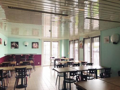- une salle à manger avec des tables, des chaises et des fenêtres dans l'établissement Fasthotel Lens Noyelles Godault, à Noyelles-Godault