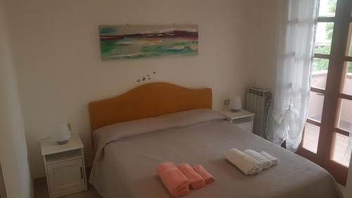 een slaapkamer met een bed met twee handdoeken erop bij La Vigna For Family in La Maddalena
