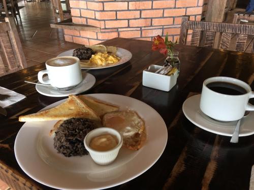 a table with two plates of food and two cups of coffee at Villa Calas in Vara Blanca
