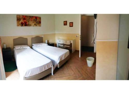 - une chambre avec deux lits, une table et une chaise dans l'établissement Casa Celeste, à Rome