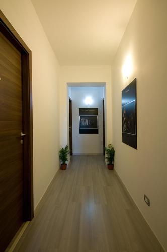 an empty hallway with two potted plants and a door at MF Hotel in Rome
