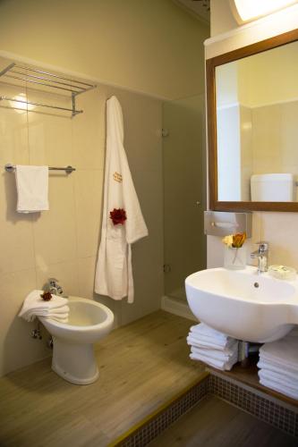 a bathroom with a sink and a toilet and a mirror at Parco del Lago Resort & SPA in Villagrande