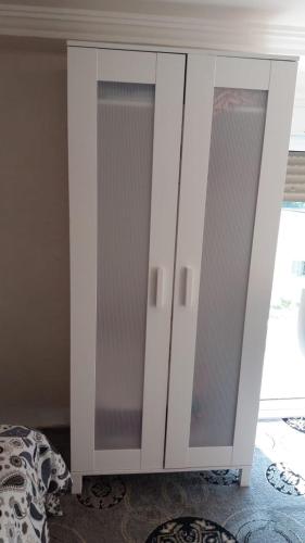a white cabinet with glass doors in a bedroom at Taza Organic Garden with view park and restaurant in Taza
