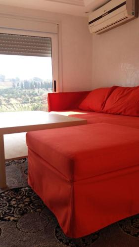 a bedroom with a red bed and a window at Taza Organic Garden with view park and restaurant in Taza