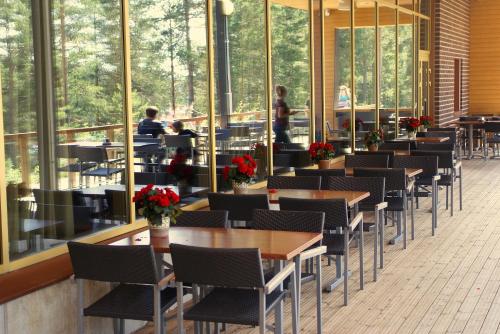 a restaurant with tables and chairs and people in the background at Finlandia Hotel Imatran Kylpylä Spa in Imatra