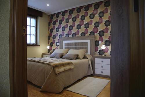 ein Schlafzimmer mit einem Bett und einer Wand in der Unterkunft Vivienda Rural La Mazuga in Cabárceno