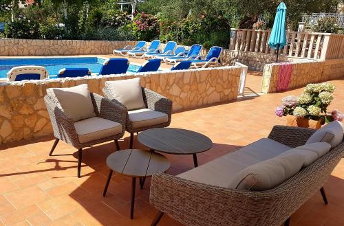 a patio with chairs and a table and a pool at Apartments Antonio in Cavtat