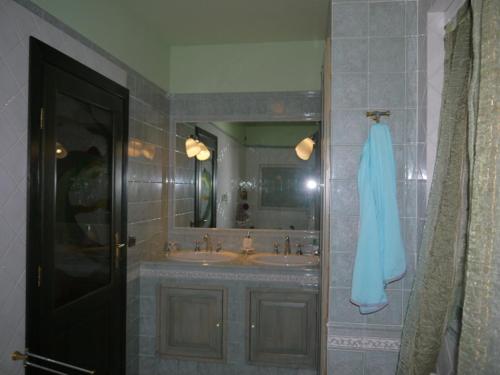 y baño con lavabo y espejo. en Villa Adry, en Monteluro