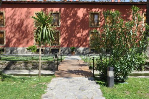 a palm tree in front of a red building at Parador de Gijón in Gijón