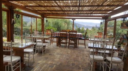 een eetkamer met tafels en stoelen en ramen bij Casa Hotel San Pedro in Villa de Leyva