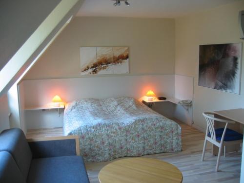 a bedroom with a bed and a couch and a table at Hovborg Kro in Hovborg