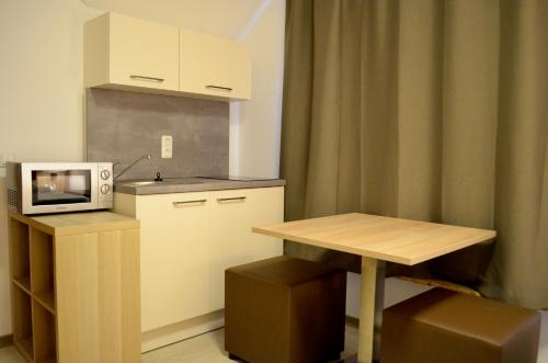 a small kitchen with a table and a microwave at Hana Aparthotel in Hamburg