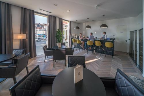 a restaurant with people sitting at tables and chairs at Bellevue Superior City Hotel in Šibenik