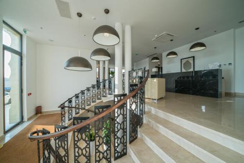 a lobby with a staircase in a building at Bellevue Superior City Hotel in Šibenik