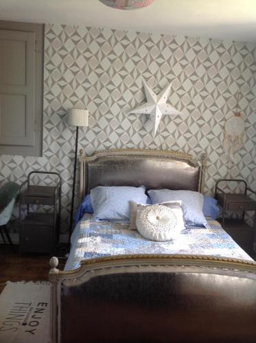 - une chambre dotée d'un lit avec une étoile sur le mur dans l'établissement Les Cailloux blancs, à Verneuil-sur-Vienne