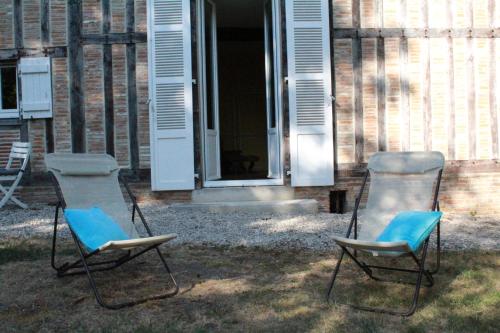 two chairs sitting in front of a house at Le Gîte de Saint Phal in Saint-Phal