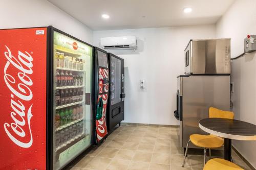 a coca cola refrigerator and a table in a room at Motel 6-Las Vegas, NV - Motor Speedway in Las Vegas