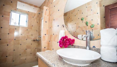 ein Bad mit einem Waschbecken und einem Spiegel in der Unterkunft Rio Dulce Ocean View Penthouse V-16 in Iguana