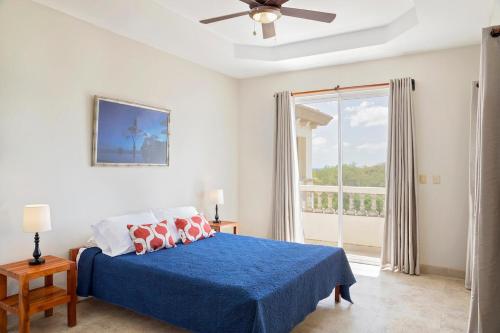 a bedroom with a blue bed and a large window at Rio Dulce Ocean View Penthouse V-16 in Iguana