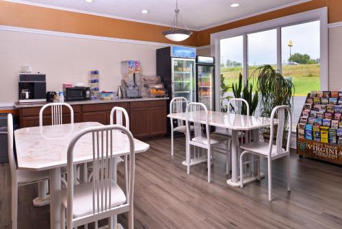 a restaurant with white tables and chairs and a counter at Americas Best Value Inn Richmond South in Richmond