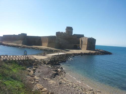 a castle sitting on the edge of the ocean at B&B "Raggio di Sole" in Le Castella