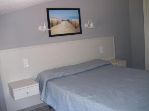 a bedroom with a bed and a picture on the wall at Hôtel Casa di Mama in Porto-Vecchio