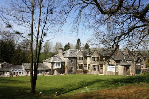 a large stone house with a large yard at The Rochester Wing Orton Hall in Orton