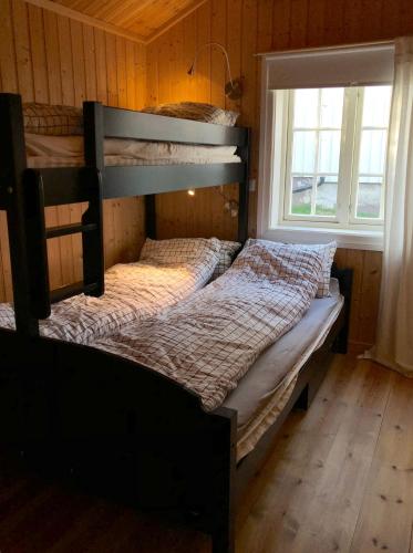 a bedroom with two bunk beds and a window at Svenskveien 23b in Røros