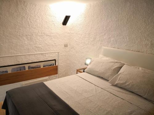 ein Schlafzimmer mit einem Bett und einer Lampe an der Wand in der Unterkunft Dimora Vallisa in Bari