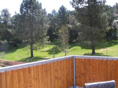 a wooden fence with trees in the background at Hôtel Casa di Mama in Porto-Vecchio