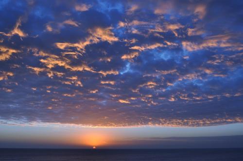 a cloudy sky over the ocean at sunset at Hotel Golf Internacional in Santa Teresita