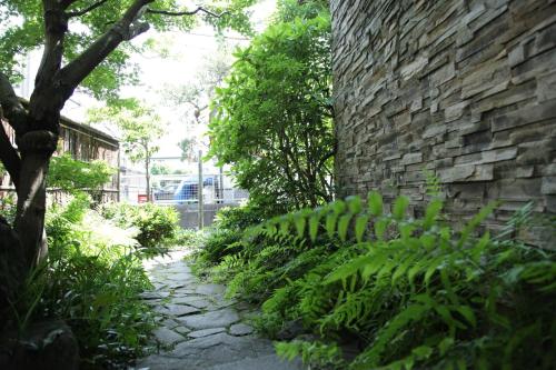 a stone path next to a brick wall at Kasumi-an in Kumamoto