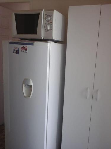 a microwave sitting on top of a white refrigerator at Cabanas bahia inglesa in Bahia Inglesa