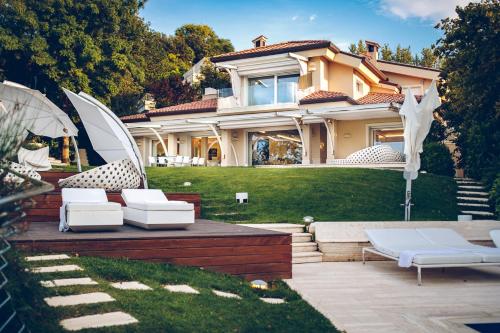a house with chairs and an umbrella in the yard at Villa STAMIRA in Ancona