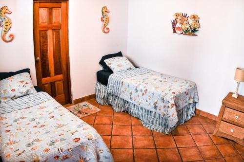 - une chambre avec 2 lits dans une chambre avec un couvre-lit dans l'établissement Villas Iguana A-8 Beachfront Condo, à Iguana