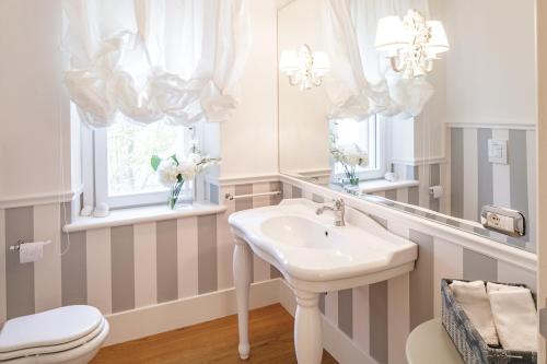 a bathroom with a sink and a toilet and a mirror at Villa STAMIRA in Ancona